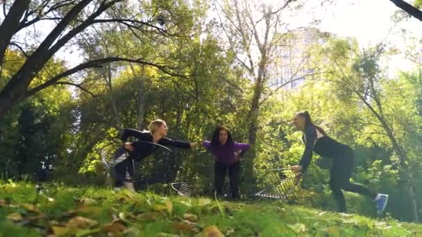 Підійдуть дівчата, що тягнуться на зеленому пагорбі в громадському парку — стокове відео