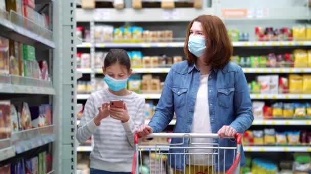 Mère et fille achetant des bonbons au supermarché pendant la pandémie — Video