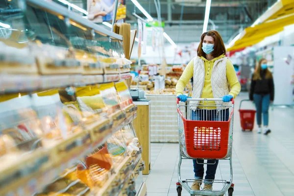 Salgın sırasında pastanede alışveriş arabalı genç bir kadın.