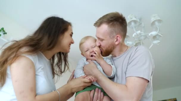 Älskade föräldrar håller och kysser pojke — Stockvideo