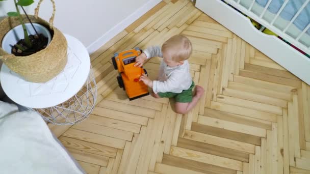 Petit garçon jouant avec une voiture jouet à la maison — Video