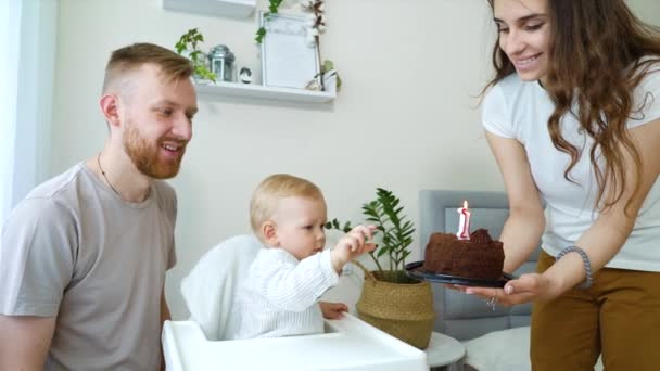 Familia feliz teniendo la primera fiesta de cumpleaños del niño en casa — Vídeo de stock