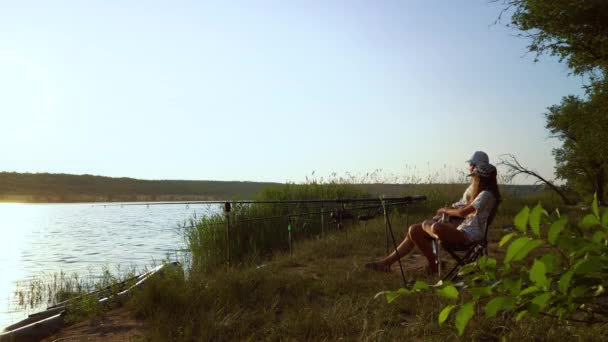 Parent and child spending time together fishing on river bank — Stock Video