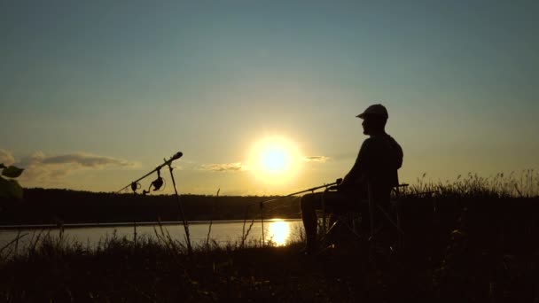 Silhouette eines Fischers, der bei Sonnenuntergang Alkohol trinkt — Stockvideo