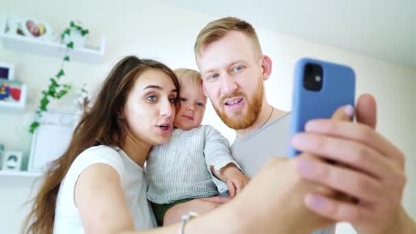 Šťastná rodina s dítětem video volání příbuzných pomocí smartphonu — Stock video