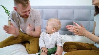 Mutlu ebeveynler ve şirin bebek el çırpıyor.