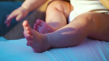 Piknik sırasında babasının üzerine oturan çıplak ayaklar.