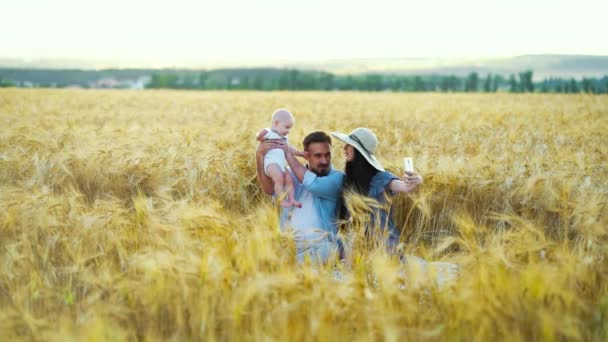 Kocası ve bebeği buğday tarlasından akan kadın vlogcu — Stok video