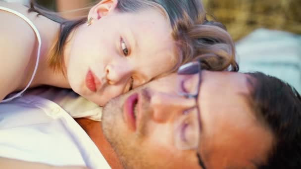Маленькая девочка трогает лицо отца на пикнике в сельской местности — стоковое видео