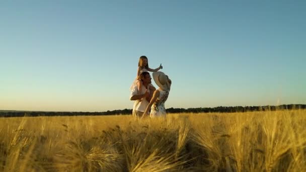 Pais felizes e filhinha dançando no campo de trigo ao pôr do sol — Vídeo de Stock
