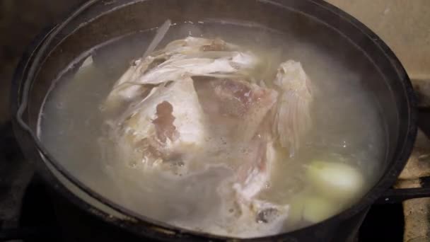 Matlagning fisksoppa i sot täckt bowlare utanför — Stockvideo