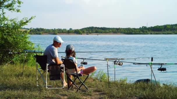 Padre e figlia a parlare durante la pesca lungo il fiume — Video Stock