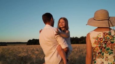 Baba, kızı kucağında taşırken, o da komik suratlar yapıyor.