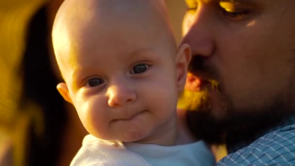 Retrato de bebé sentado en las manos de padre y mirando a la cámara — Vídeos de Stock