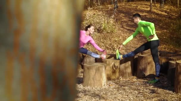 Glückliche junge Familie übt im Herbstwald — Stockvideo