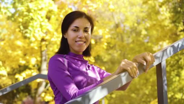 Cheerful black girl in sportswear posing against yellow trees — Stock Video