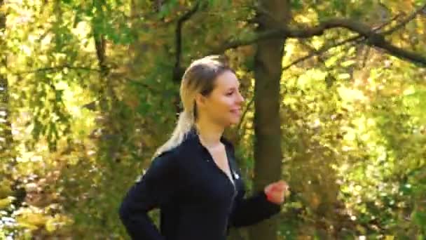 Blonde girl jogging outside on sunny day — Stock Video