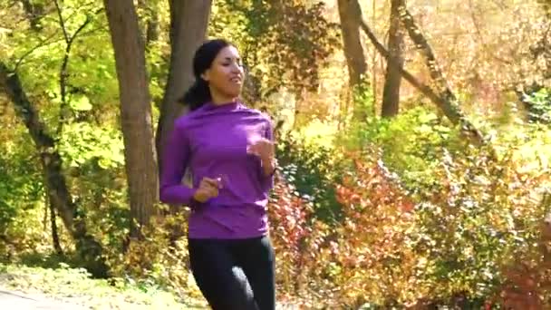 Sort pige jogging med venner i solrig park – Stock-video