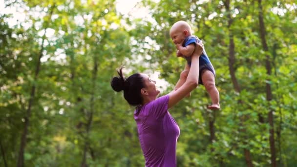 Moeder en baby hebben plezier in groen park — Stockvideo