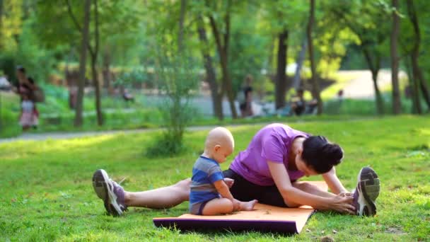 Fit vrouw training met baby in het park — Stockvideo