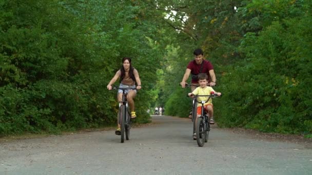 Счастливый семейный велосипед в парке и высокая пятерка — стоковое видео