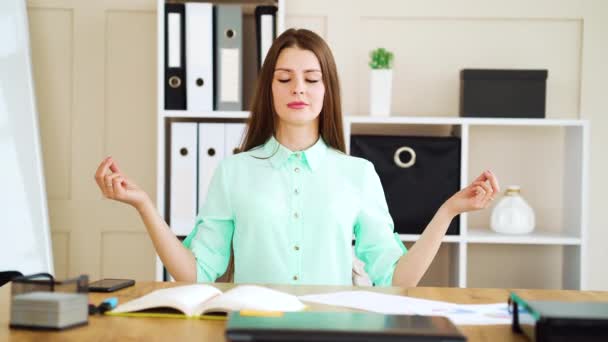 Junge Frau mit geschlossenen Augen meditiert im Büro — Stockvideo