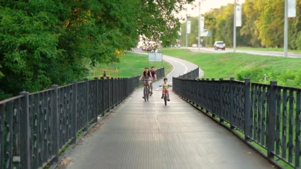 Семейная поездка на велосипеде и пересечение металлического моста — стоковое видео
