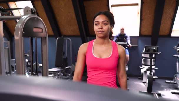 Schwarze Frau trainiert auf Laufband im Fitnessstudio — Stockvideo