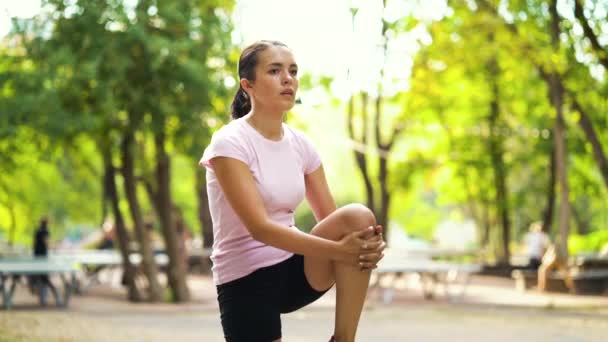 Fit vrouw stretching benen voor joggen in het park — Stockvideo