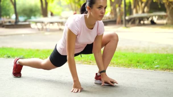 Mujer atlética estirando las piernas antes de correr en el parque — Vídeos de Stock