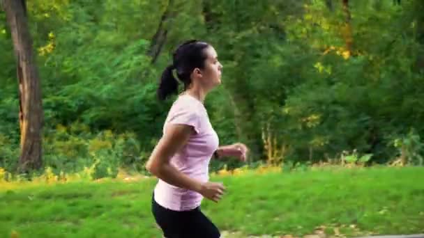 Mujer joven corriendo en el parque verde — Vídeos de Stock