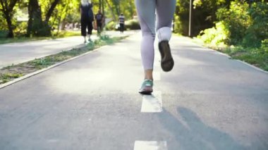 Yolda koşan spor ayakkabılı bir kadın.