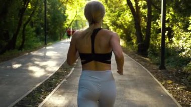 Güneşli parkta koşan zinde sarışın.