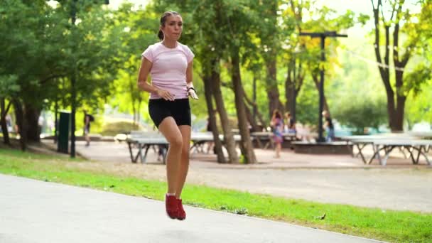Deportiva mujer corriendo en su lugar y calentando los pies en el parque — Vídeos de Stock