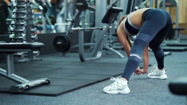 Sportliche Frau streckt Beine im Fitnessstudio — Stockvideo