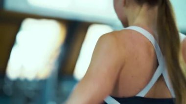 Spor salonunda omuzları için egzersiz yapan formda bir kadın.