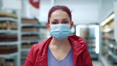 Tıp maskeli kadın alışveriş merkezinde poz veriyor.