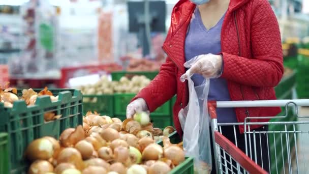 Mujer recogiendo cebollas en la tienda durante pandemia — Vídeo de stock
