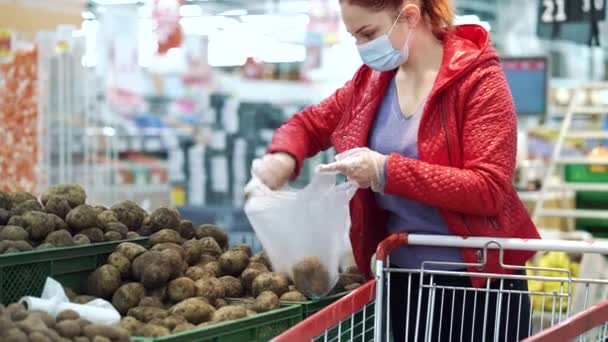 Kadın salgın sırasında süpermarkette patates topluyor. — Stok video