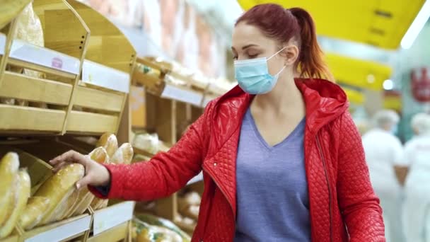 Young woman buying fresh bread in bakery during pandemic — Stock Video