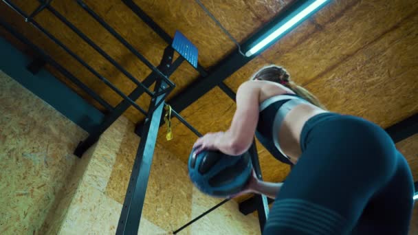 Vrouw hurken en gooien bal in sportschool — Stockvideo