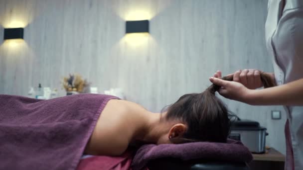 Femeie obtinerea de păr trăgând masaj în salon spa — Videoclip de stoc