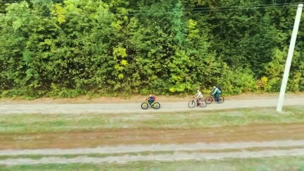 가족끼리 자전거를 타고 숲 근처를 돌아다닌다 — 비디오