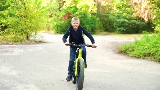 Chłopiec jazda na rowerze w parku jesienią — Wideo stockowe