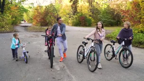 Familie van vijf wandelingen met fietsen in het najaarspark — Stockvideo