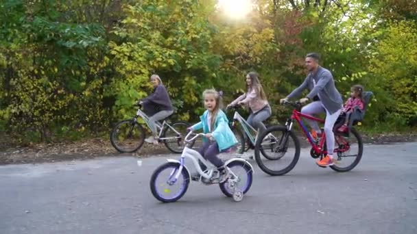 Big family riding bicycles in park in early autumn — Stock Video