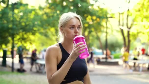 Mujer bebiendo agua después de entrenar en el parque — Vídeos de Stock