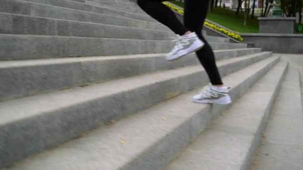 Kobieta nogi w odzieży sportowej biegnie na górę w parku — Wideo stockowe