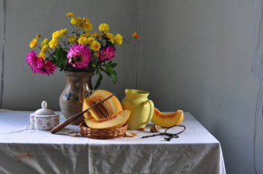 Bir buket elmayla, elmayla, çiçeklerle ve sütle dolu tahta masada.