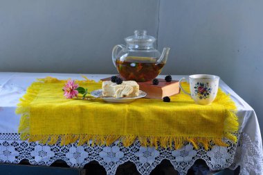 Bir fincan çay ve bir buket çiçek.